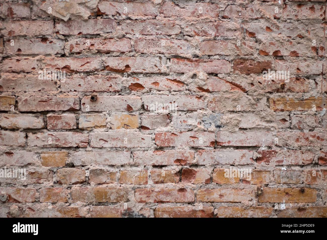 Vecchio muro di mattoni. Mattone sciolto. Superficie della parete. Tessitura di pietra. Lavori in pietra. Foto Stock