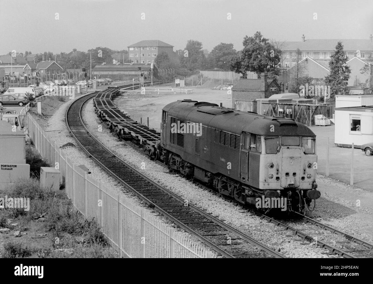 Una locomotiva diesel classe 31 numero 31418 si dirige fuori dalla filiale di Greenford verso West Ealing con un treno di carri piatti container il 2nd settembre 1991. Foto Stock