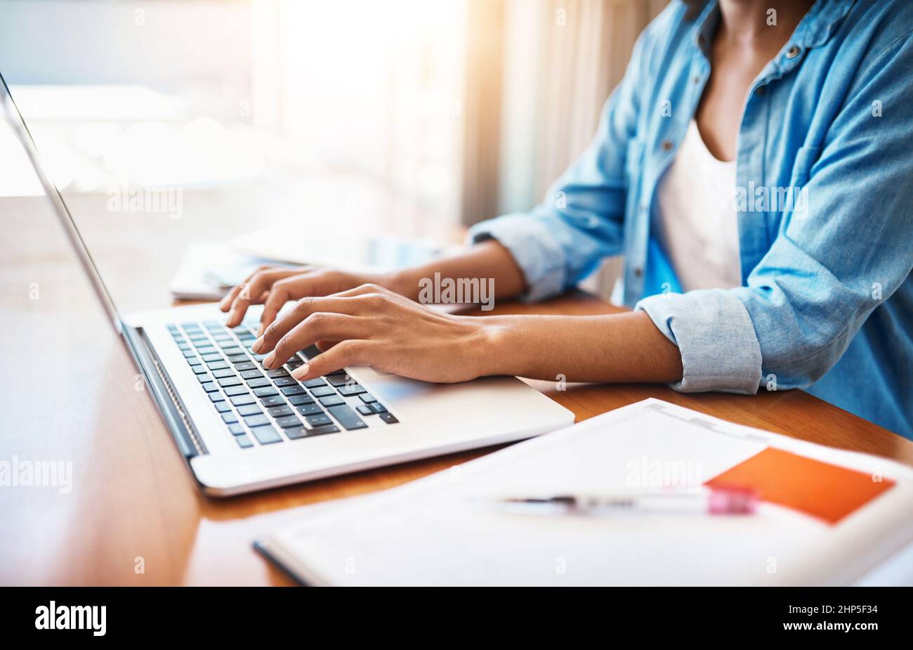 Mettendo in un certo lavoro duro durante il fine settimana. Scatto di una giovane donna irriconoscibile che lavora sul suo laptop a casa. Foto Stock