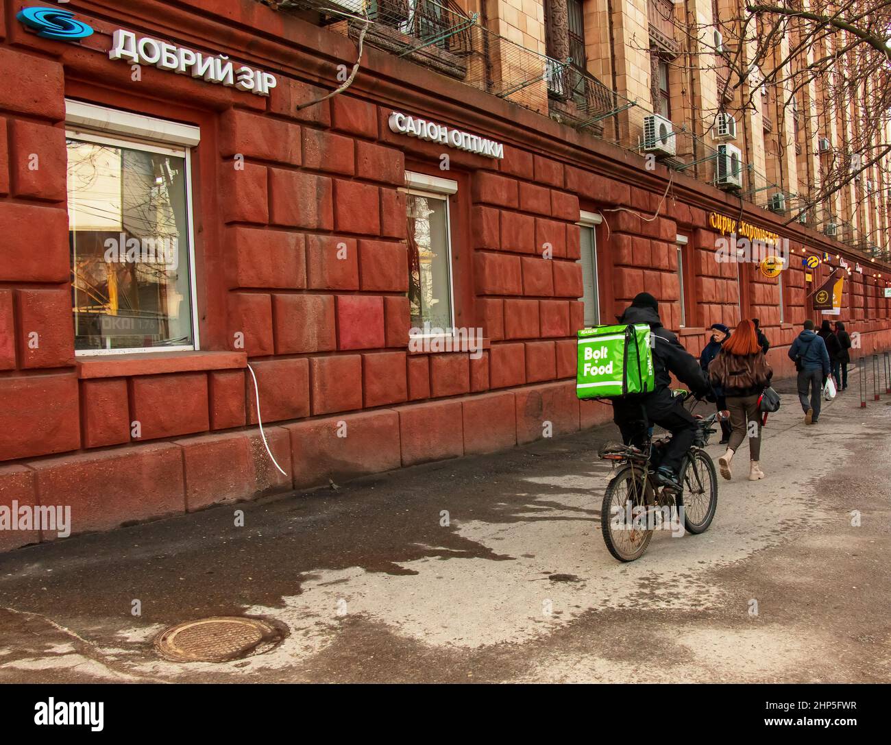 Dnepropetrovsk, Ucraina - 02.09.2022: Un corriere di servizio di consegna con una borsa termica su una bicicletta gira intorno alla città. Consegna di cibo domestico. Foto Stock