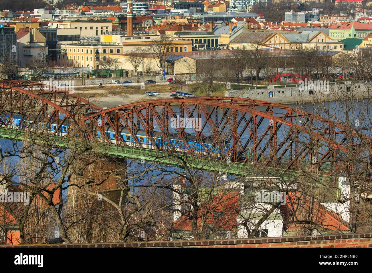 Locomotiva di classe 162 delle Ferrovie ceche di Ceske Drahy che attraversano il fiume Moldava, con archi in ferro rosso o acciaio sul ponte, Praga, repubblica Ceca Foto Stock