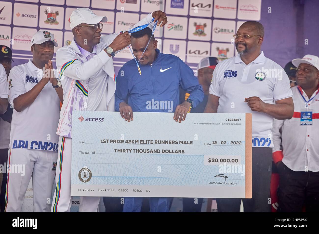 Vincitore della maratona a 1st posti, Geleta Ulfata riceve una medaglia e un premio in denaro dopo aver gareggiato nella maratona di Access Bank Lagos il 12 febbraio 2022. Foto Stock