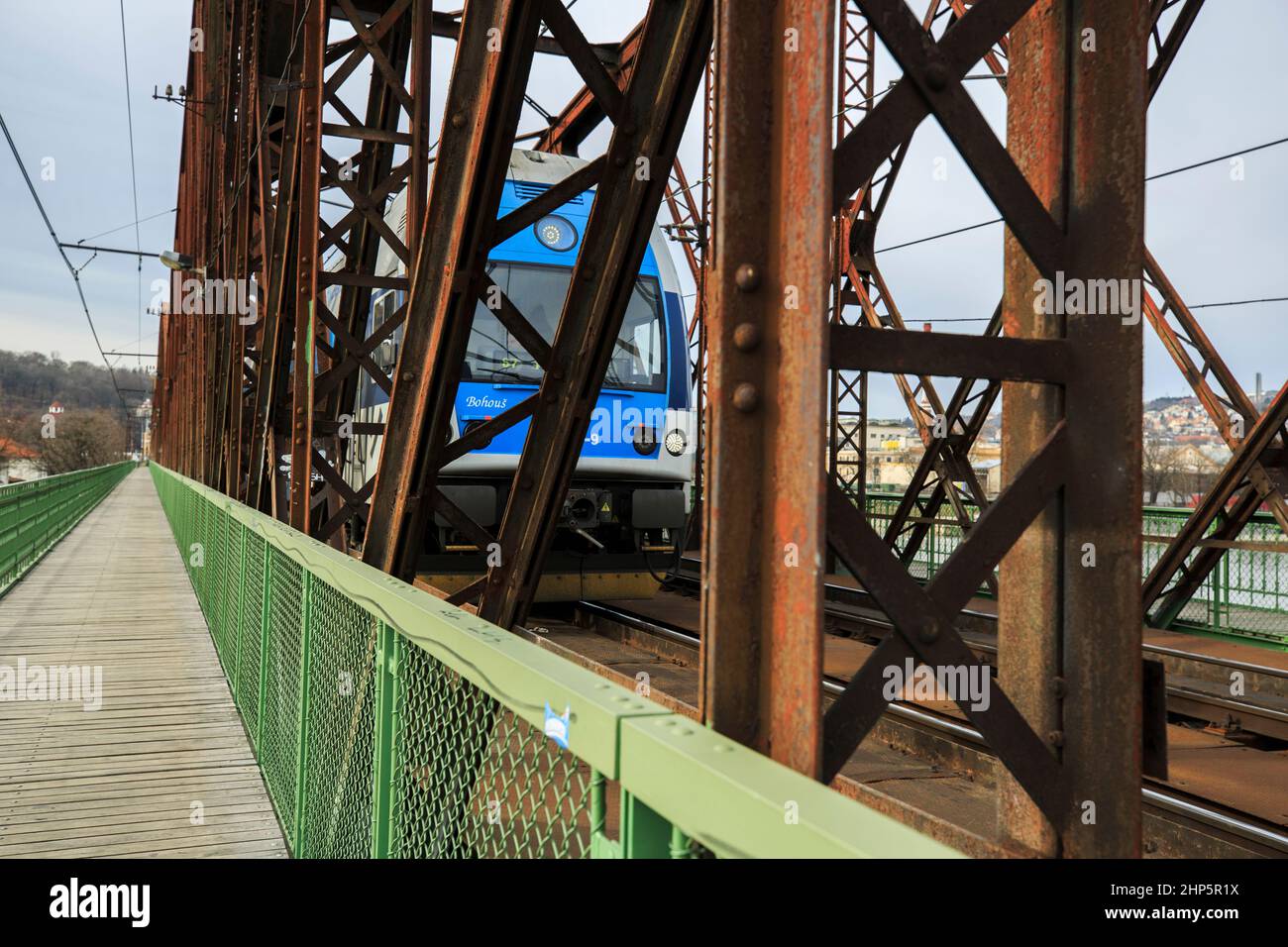 Locomotiva di classe 162 delle Ferrovie ceche di Ceske Drahy che attraversano il fiume Moldava, con passerella pedonale in legno oltre ai binari, Praga, repubblica Ceca Foto Stock