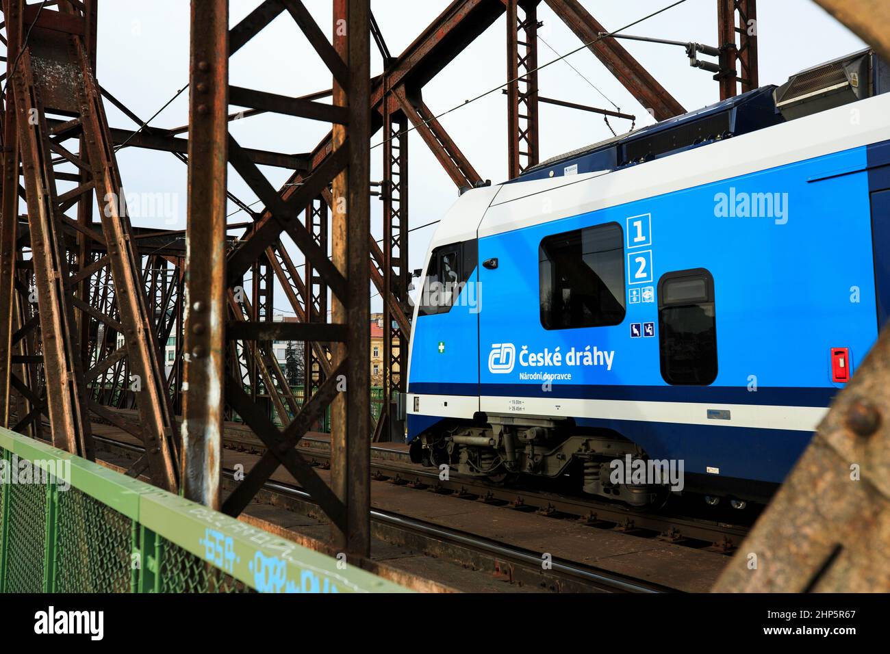 Locomotiva di classe 162 delle Ferrovie ceche di Ceske Drahy che attraversano il fiume Moldava, con passerella pedonale in legno oltre ai binari, Praga, repubblica Ceca Foto Stock