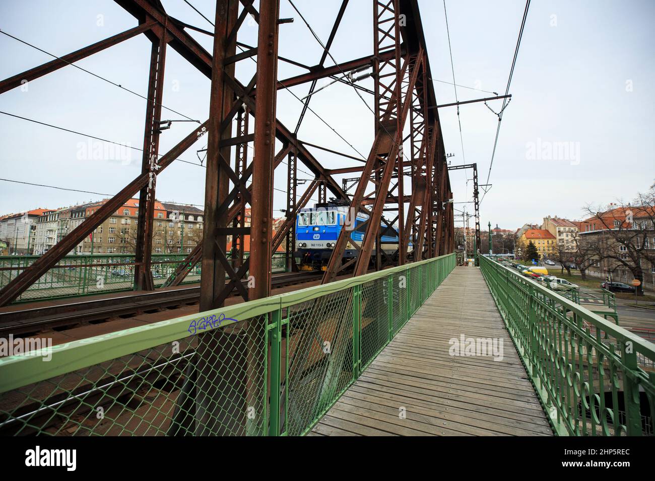 Locomotiva di classe 162 delle Ferrovie ceche di Ceske Drahy che attraversano il fiume Moldava, con passerella pedonale in legno oltre ai binari, Praga, repubblica Ceca Foto Stock