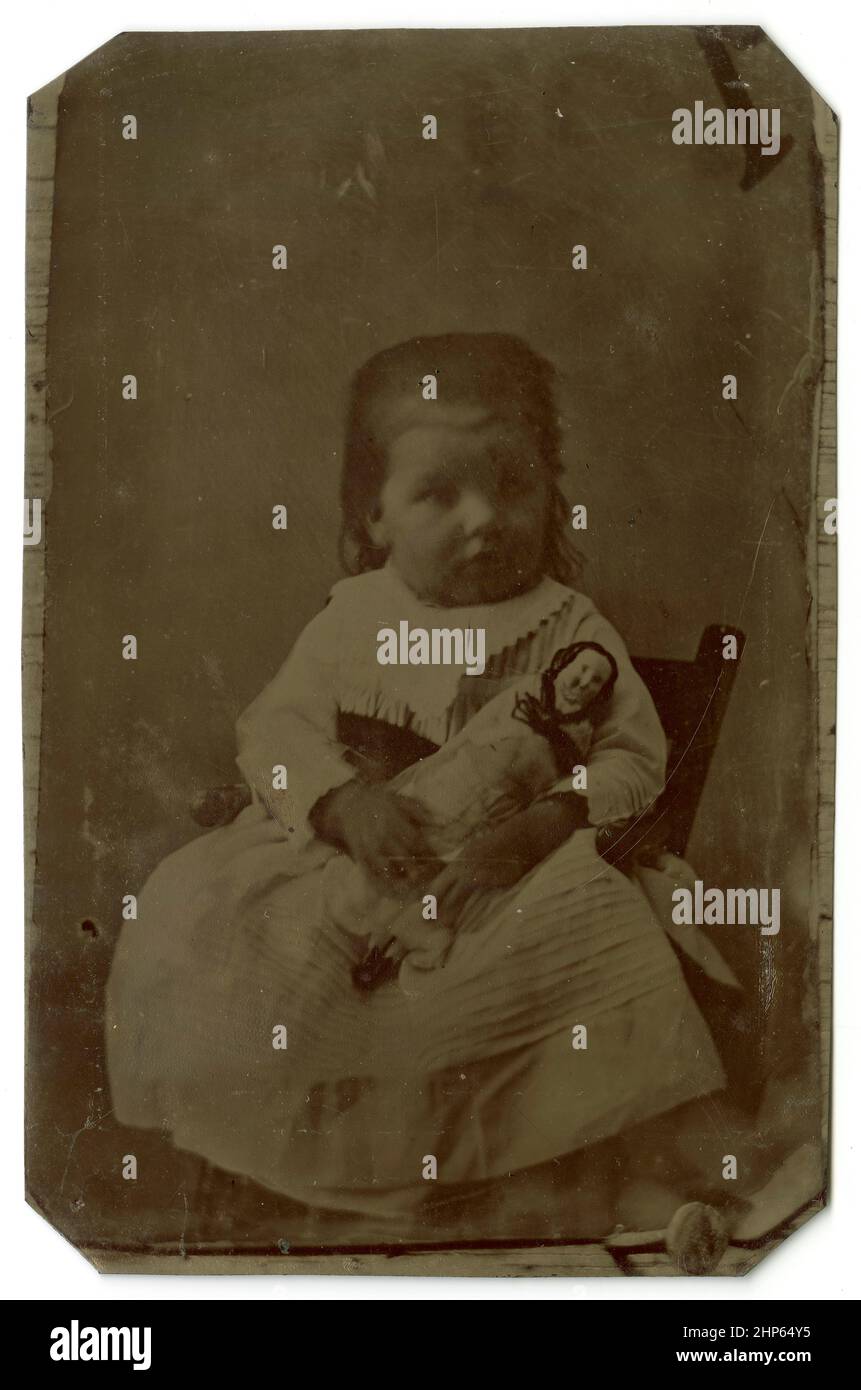 Antica fotografia di circa 1860 tintype, ragazza giovane con la sua bambola. Località sconosciuta, Stati Uniti. FONTE: TINTYPE ORIGINALE Foto Stock