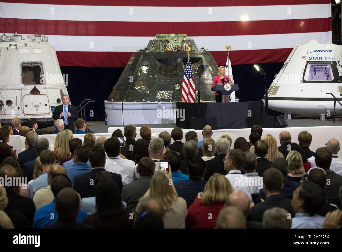 Janet Petro, vice direttore del Centro spaziale Kennedy della NASA, si rivolge ai leader delle agenzie, ai funzionari governativi degli Stati Uniti e della Florida e ai dipendenti all'interno del Vehicle Assembly Building durante una visita del vicepresidente Mike Pence. Pence ha ringraziato i dipendenti per aver avanzato la leadership americana nello spazio. Dietro il podio si trovano, da sinistra, una capsula di SpaceX Dragon volata, la navicella spaziale Orion volata sul test esplorativo del volo 1 nel 2014, e un beffo della Boeing CST-100 Starliner Foto Stock