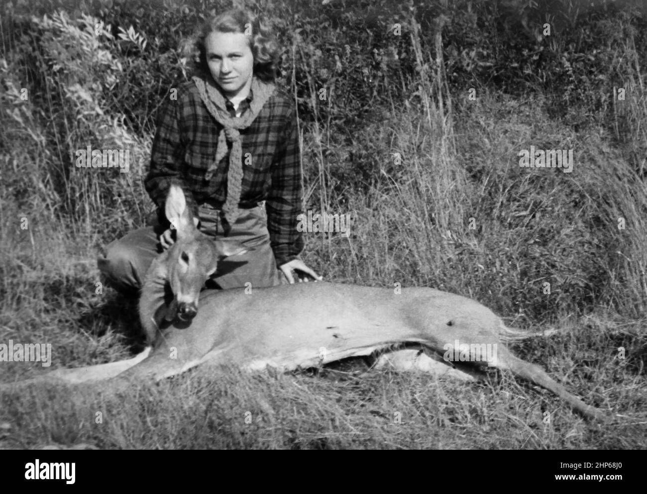 Una giovane donna mostra il cervo che ha sparato, ca. 1950. Foto Stock