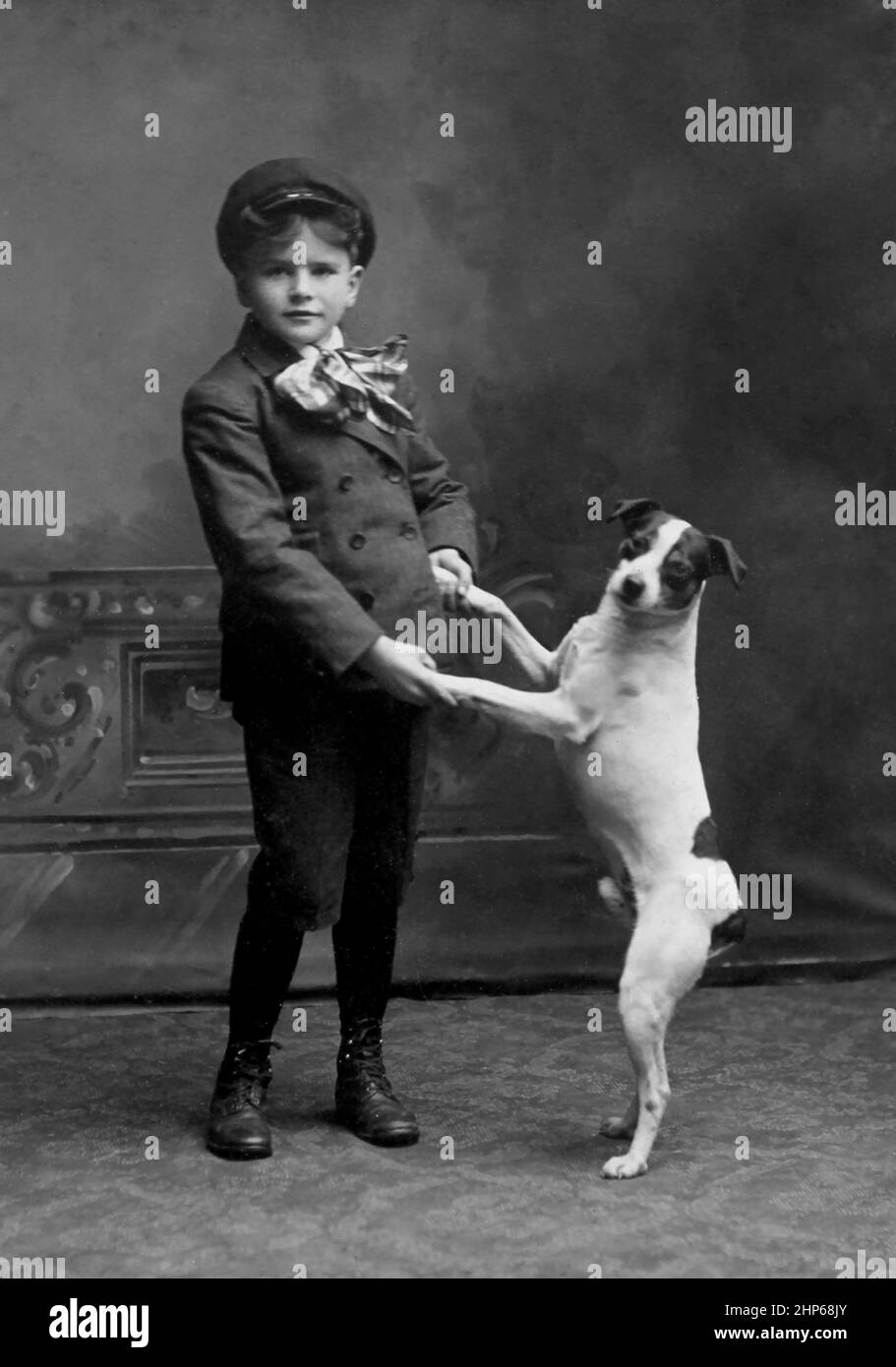 Un giovane ragazzo ama ballare con il suo cane, ca. 1900. Foto Stock