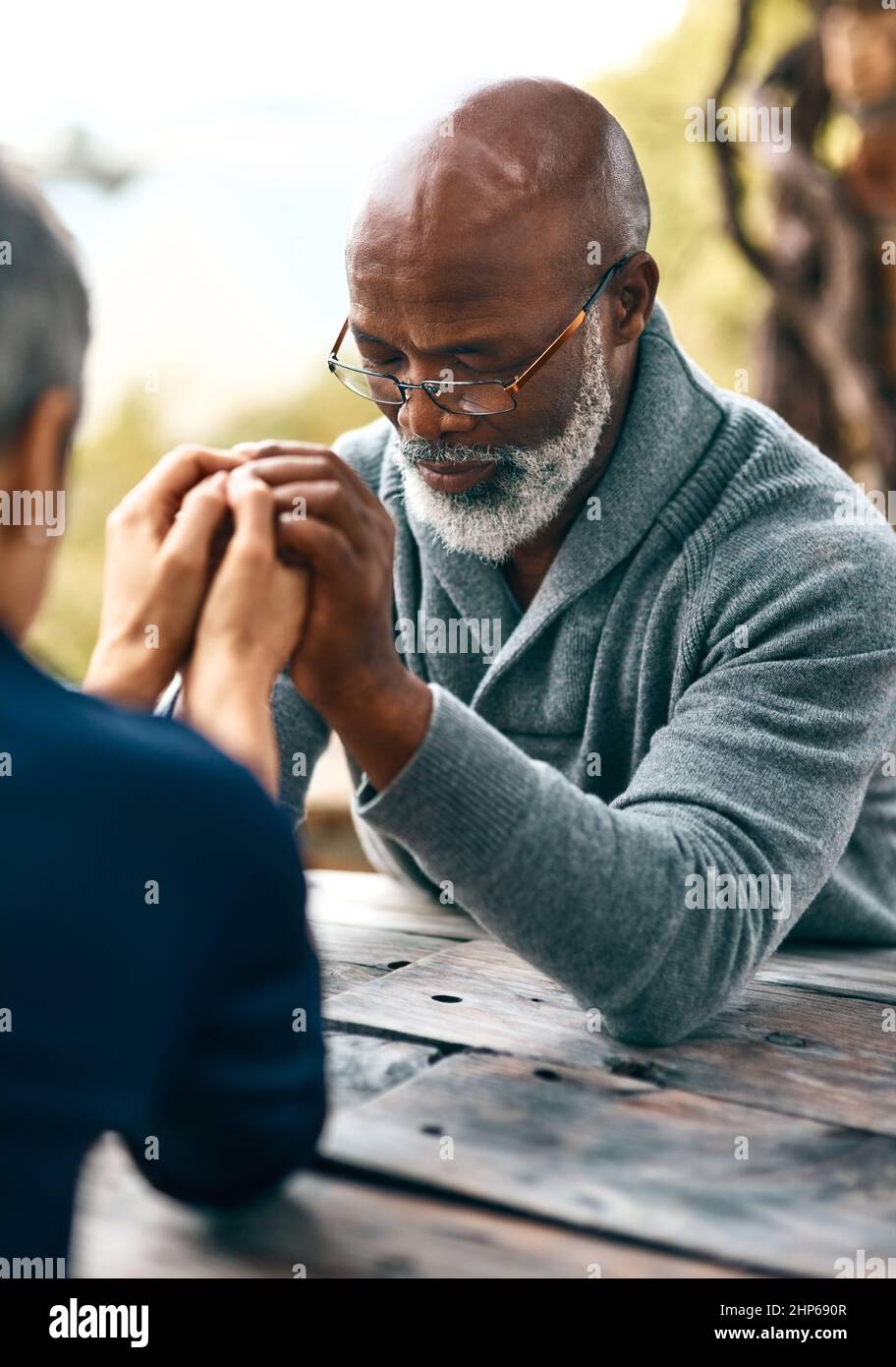 Le coppie che pregano insieme, rimangono insieme. Scatto corto di una coppia anziana che prega all'aperto. Foto Stock