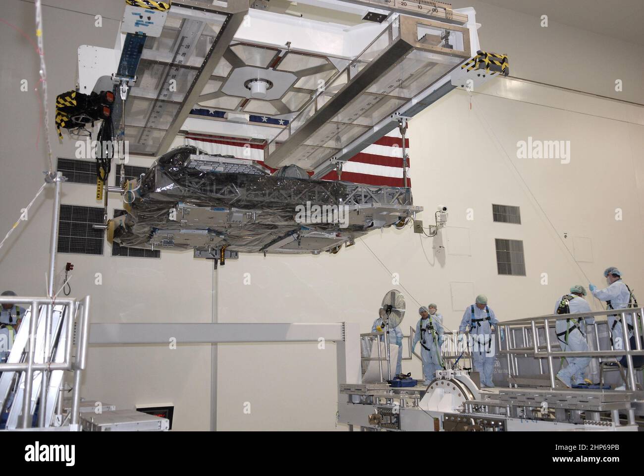 Nell'impianto di elaborazione della stazione spaziale del Centro spaziale Kennedy della NASA, una gru a ponte sposta il vettore di logistica espresso, o ELC, in un supporto a rotazione ca. 2009 Foto Stock