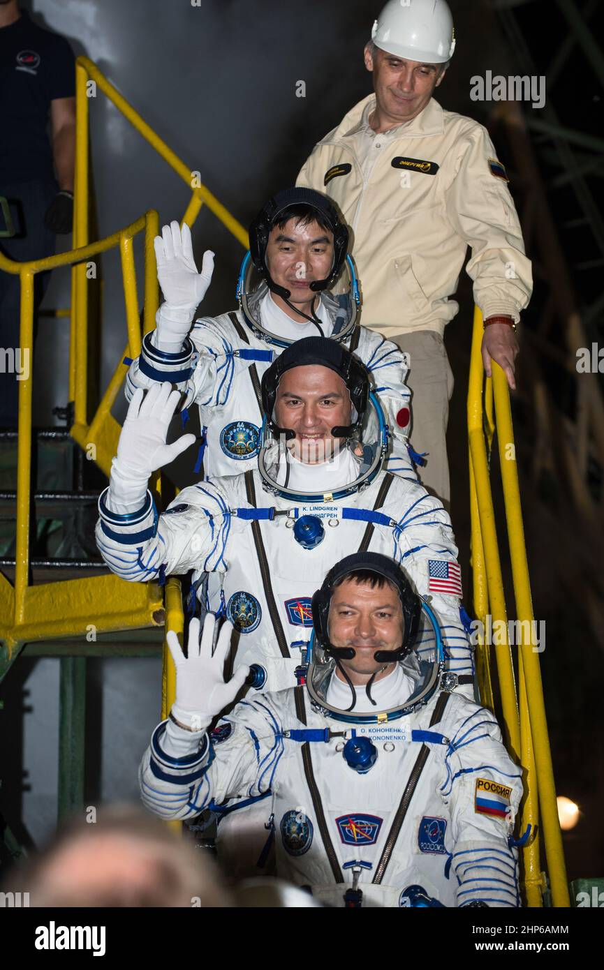 Expedition 44 ingegnere di volo Kimiya Yui, della Japan Aerospace Exploration Agency (JAXA), TOP; L'ingegnere di volo Kjell Lindgren della NASA, centro, e il comandante di Soyuz Oleg Kononenko dell'Agenzia spaziale Federale Russa (Roscosmos), in basso, saluta prima di salire a bordo del veicolo spaziale Soyuz TMA-17M per il lancio, giovedì 23 luglio 2015 presso il Cosmodrome di Baikonur in Kazakhstan. Foto Stock