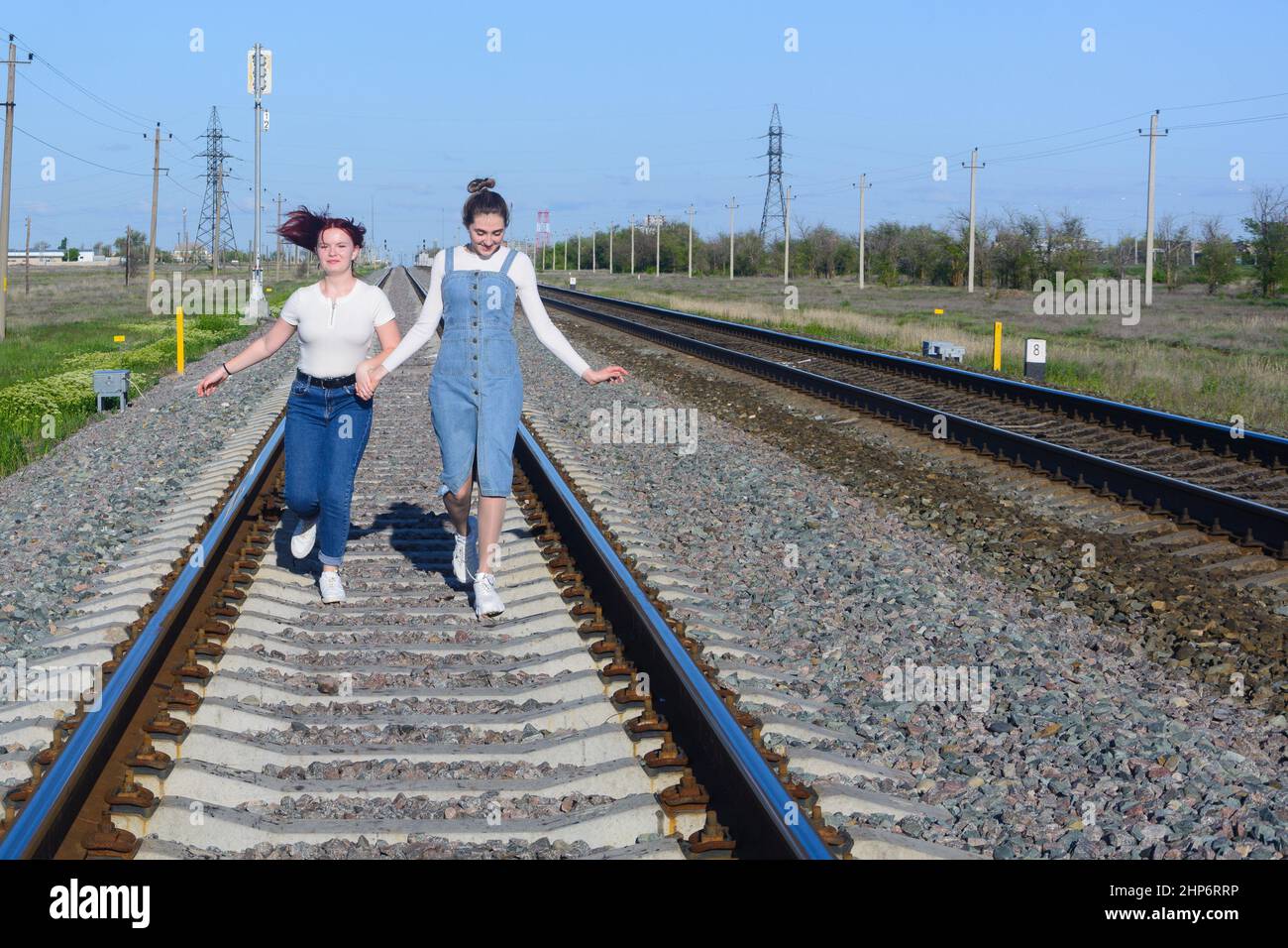 La ragazza adolescente e la giovane donna corrono lungo la ferrovia. Foto Stock