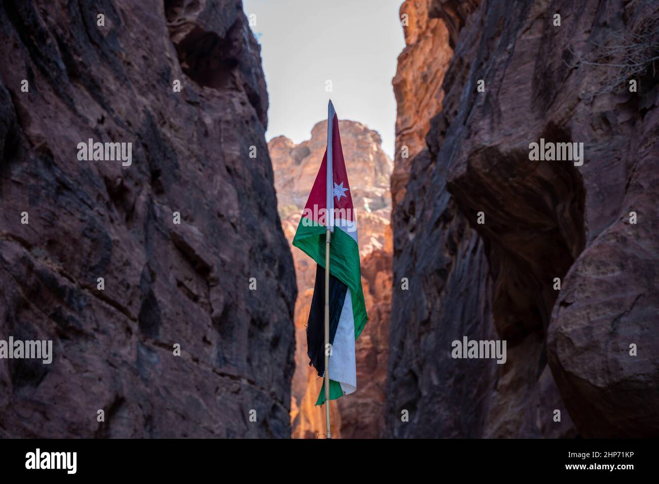 Bandiera nera, bianca, verde e rossa della Giordania che sorvola la destinazione turistica di Petra Foto Stock