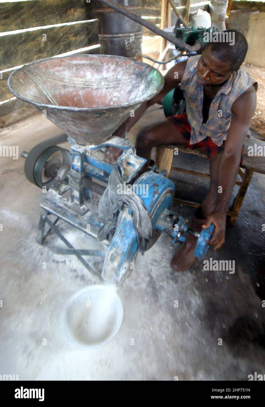 Uomo mulini mais per fare Ugali. Ugali è un tipo di porridge di mais mangiato nell'Africa orientale e centrale. Ghana Africa occidentale. Immagine GaryRoberts/worldwidefeatures.com Foto Stock