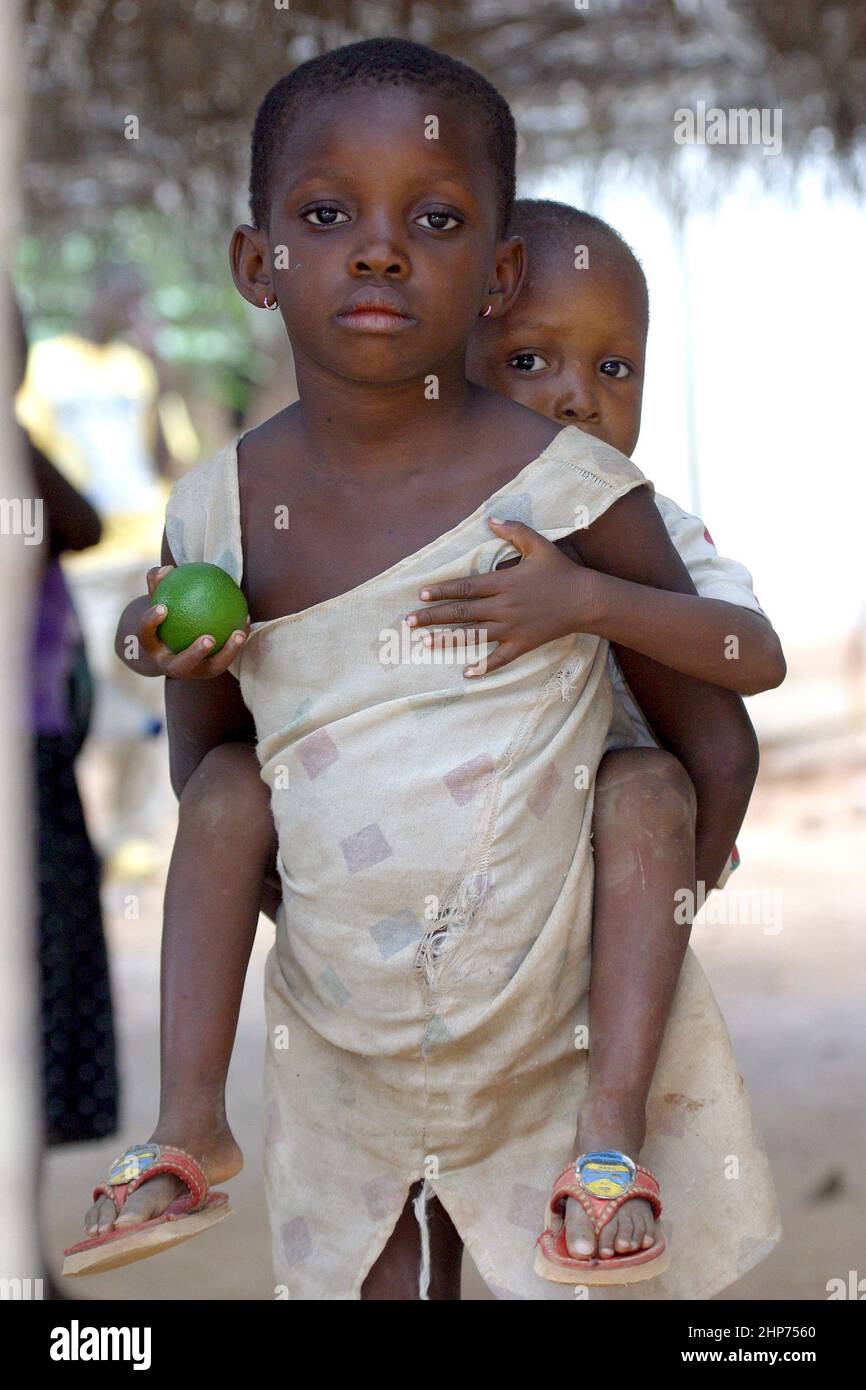Bambino giovane con calce in mano che è trasportato. Ghana Africa occidentale Foto Stock