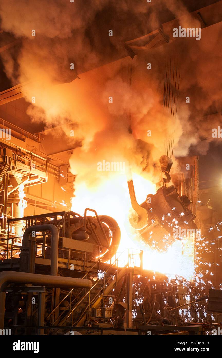 Il processo di colata dell'acciaio fuso in un forno metallurgico Foto Stock