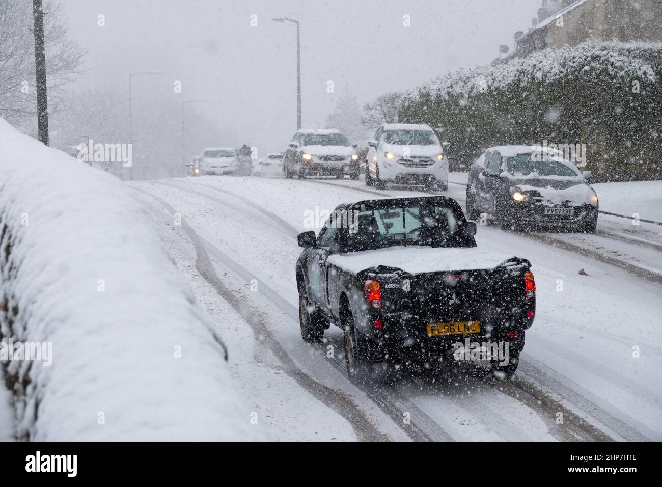 Neve e ghiaccio che causano disagi sulle colline intorno a Bradford, West Yorkshire, Regno Unito. 19th Feb 2022. Le auto lottano per muoversi su superfici invernali scivolose. Foto Stock