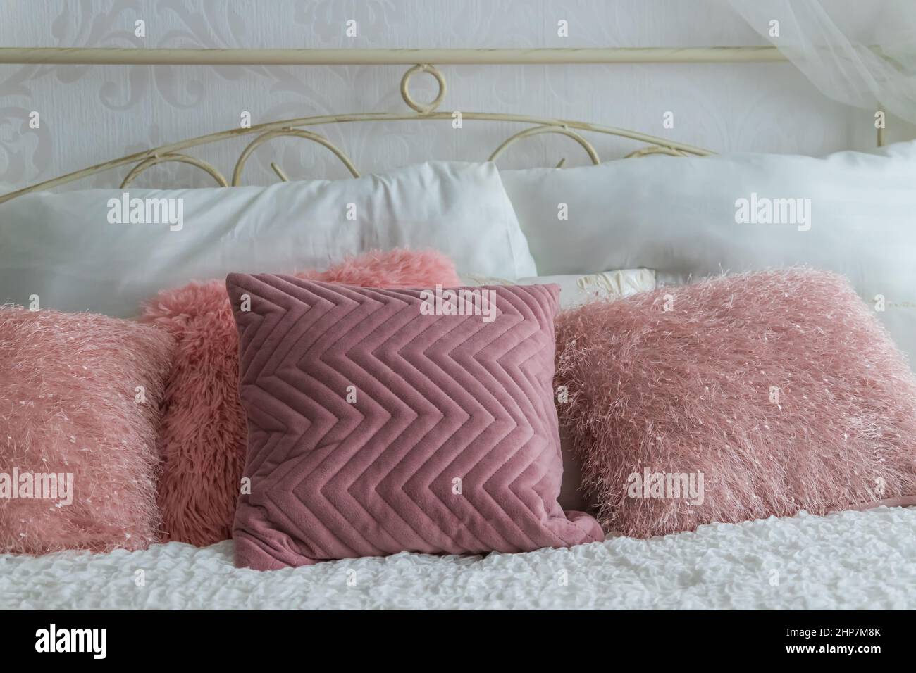 I cuscini colorati si trovano su un grande letto. Foto Stock