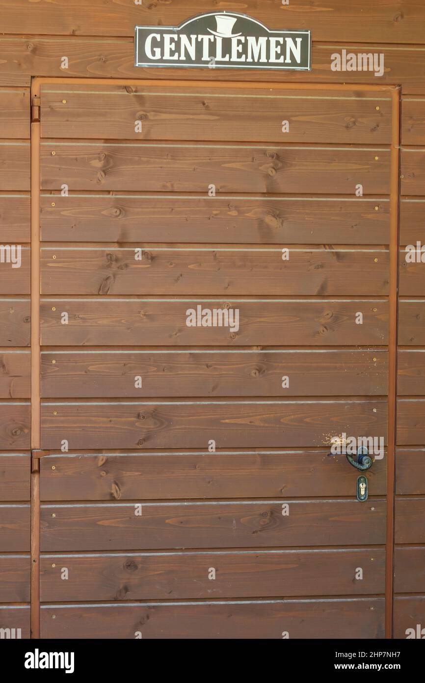 Porta di legno con maniglia su cui è scritta Gentlemen. Foto Stock