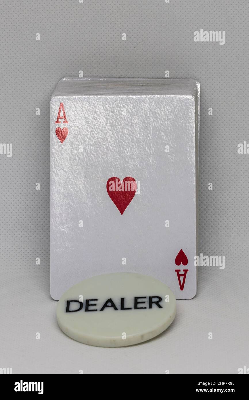 Un mazzo di carte da poker con una targa recante il mazziere di iscrizione. C'è un asso di cuori sulla carta. Foto Stock