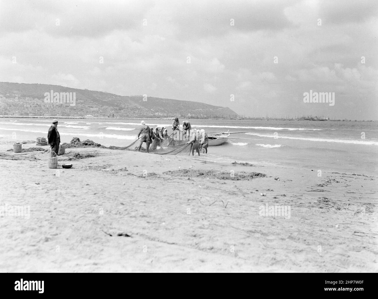 Medio Oriente Storia: Pescatori che lavorano con le loro reti sulla riva vicino Haifa Località: Israele--Haifa ca. Tra il 1940 e il 1946 Foto Stock