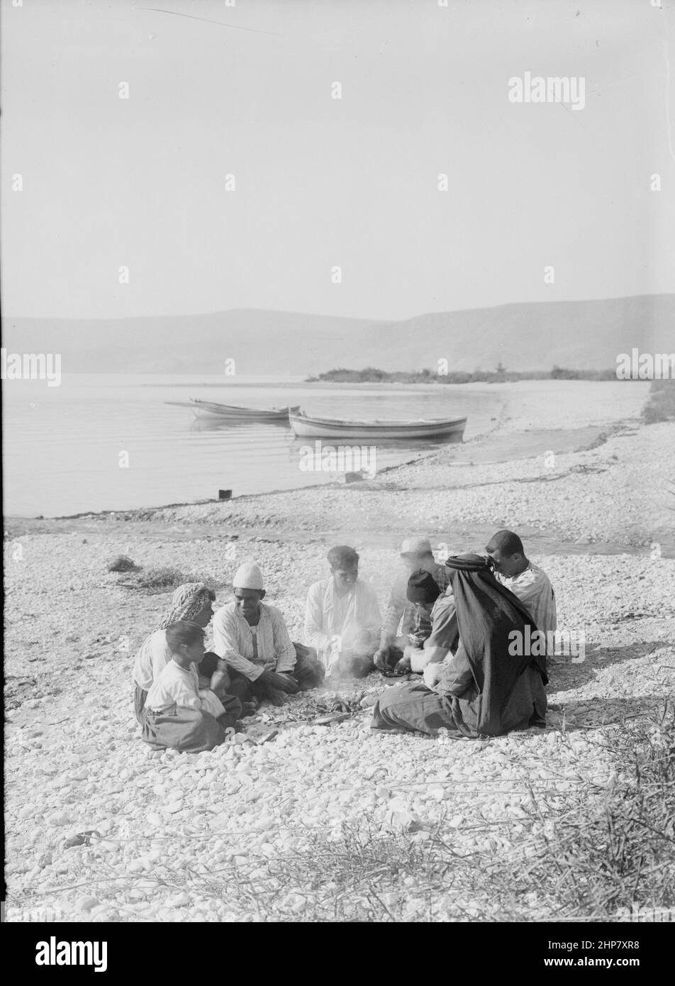 Medio Oriente Storia: Galilea pescatore seduto intorno ad un fuoco sulla riva luogo: Israele ca. Tra il 1898 e il 1946 Foto Stock