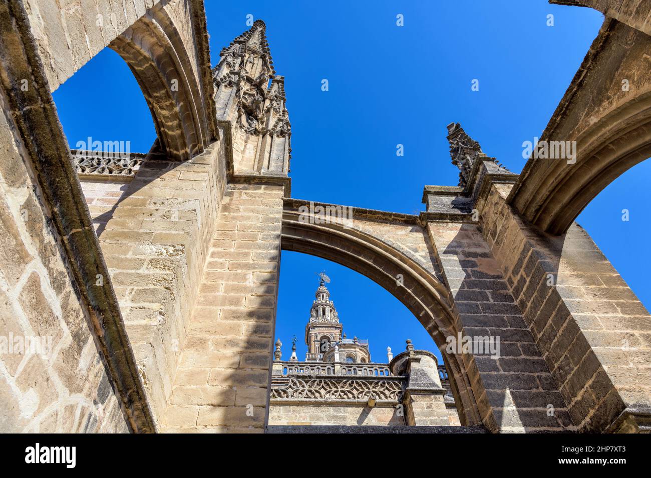 Tetto della Cattedrale di Siviglia - una vista ravvicinata da un angolo basso di pinnacoli e contrafforti volanti sul tetto della Cattedrale di Siviglia, Siviglia, Andalusia, Spagna. Foto Stock