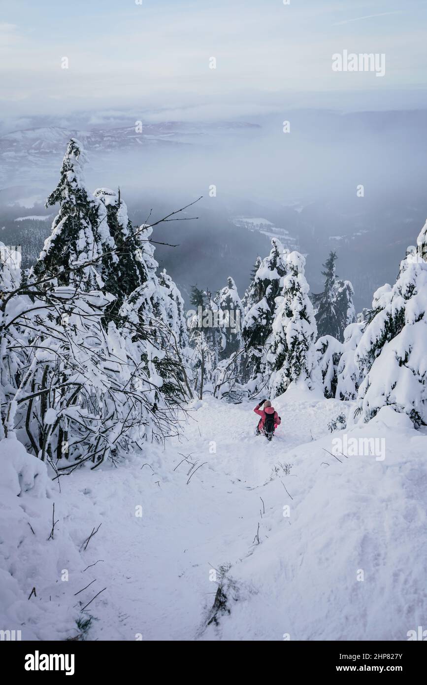 Inverno ripido sentiero in discesa lungo la montagna con neve e persona Foto Stock