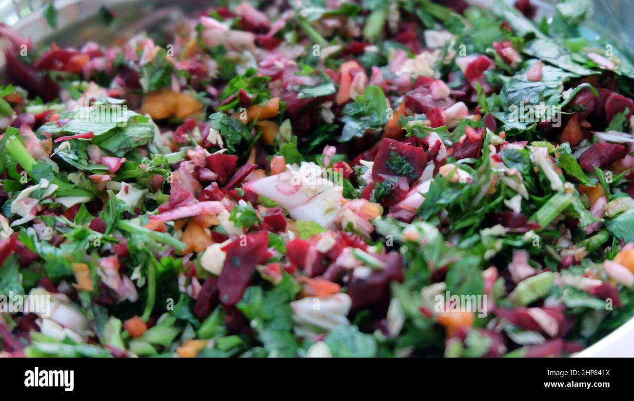 Primo piano del trito di verdure fresche e crude, con foglie di coriandolo, choy di pak, carota e barbabietola. Foto Stock
