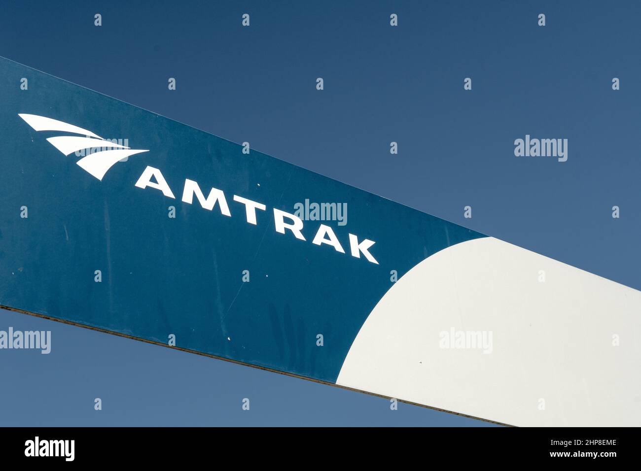 Cartello Amtrak blu e bianco sulla piccola piattaforma passeggeri. Amtrak è la linea ferroviaria passeggeri americana. Foto Stock