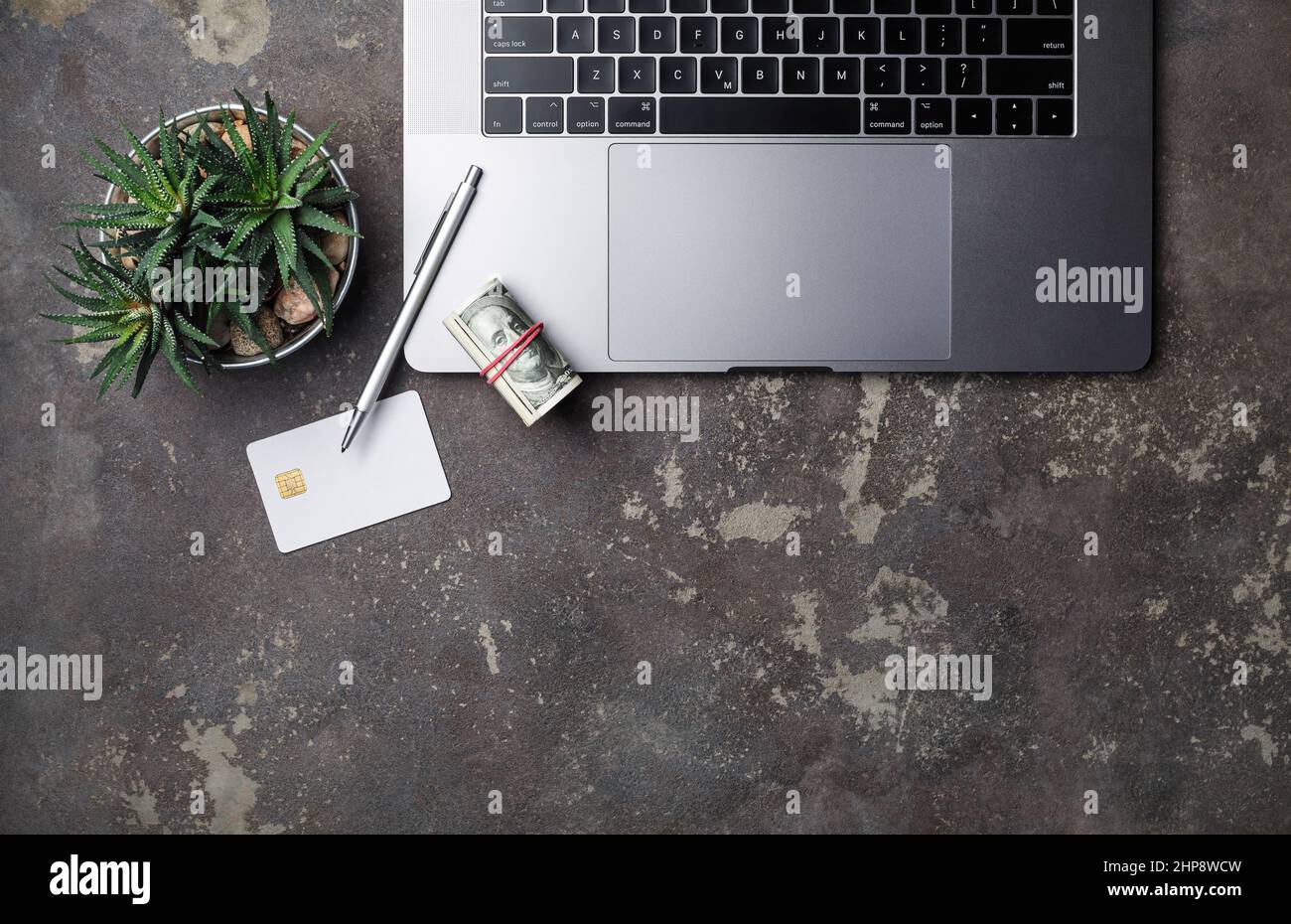 Concetto di lavoro online. Forniture per ufficio e gadget su sfondo concreto. Disposizione piatta. Foto Stock