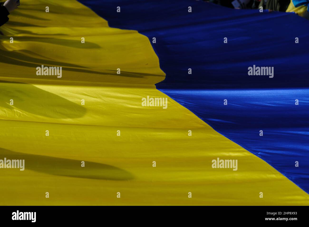 Lviv, Ucraina, 19 febbraio 2022. La gente ha una grande bandiera ucraina durante la marcia dell'unità per l'Ucraina nel centro di Lviv, tra le tensioni sul confine Ucraina-Russia. Foto Stock