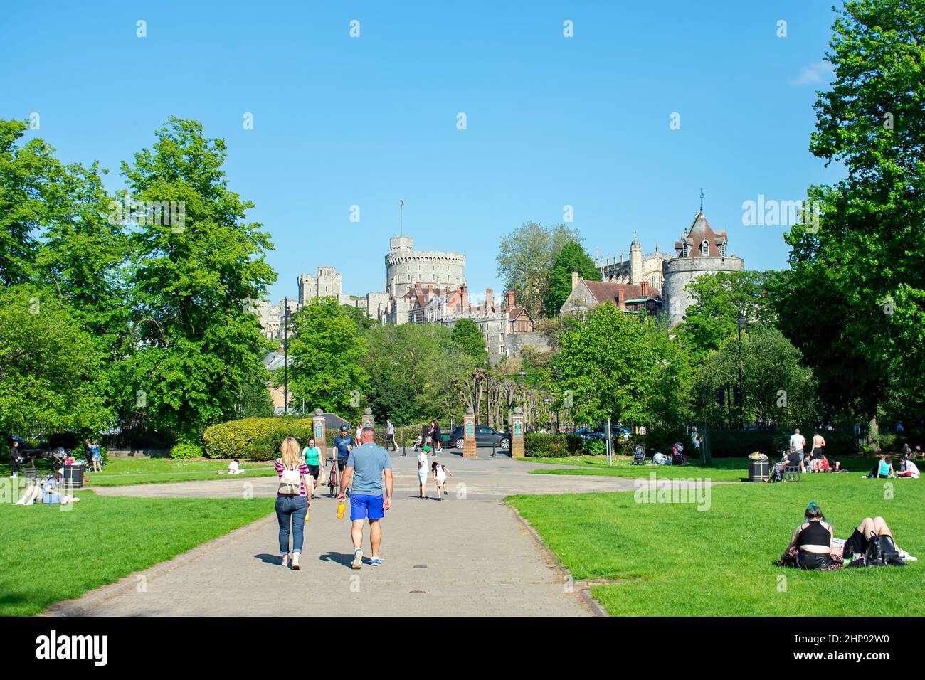 Il Castello di Windsor domina la vista dagli Alexandra Gardens a Windsor, Berkshire, Regno Unito. La gente passeggia attraverso il parco verso la città di Windsor. Foto Stock