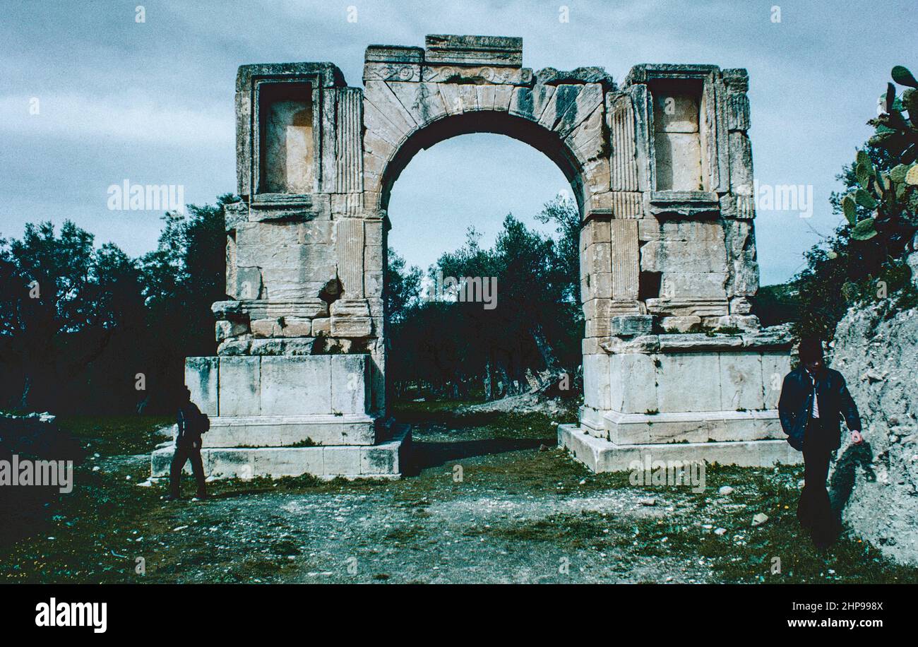 Dougga (Thugga) - Sito archeologico nel nord della Tunisia, rovine di un insediamento berbero, punico e romano, la cittadina romana meglio conservata del Nord Africa. Arco di Severus Alexander. Scansione di archivio da un vetrino. Aprile 1976. Foto Stock