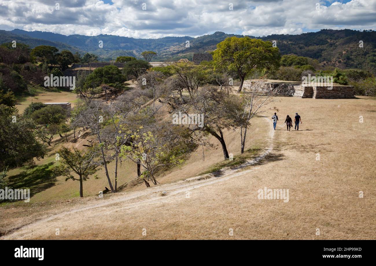 I visitatori camminano verso strutture in rovina presso lo storico sito Maya di Mixco Viejo, Guatemala Foto Stock