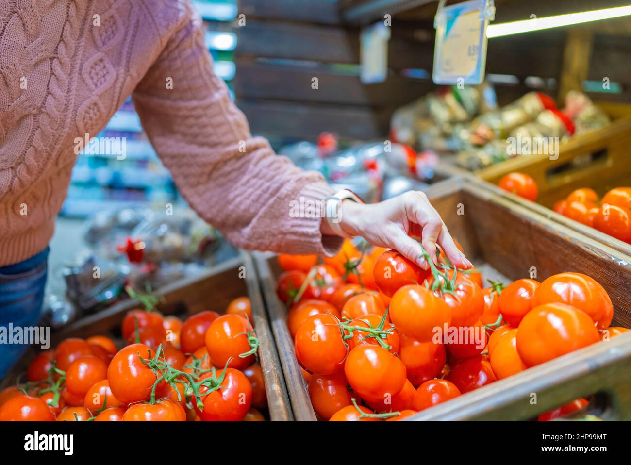 Selezione di pomodori a mano - Donna nel negozio biologico. Foto Stock