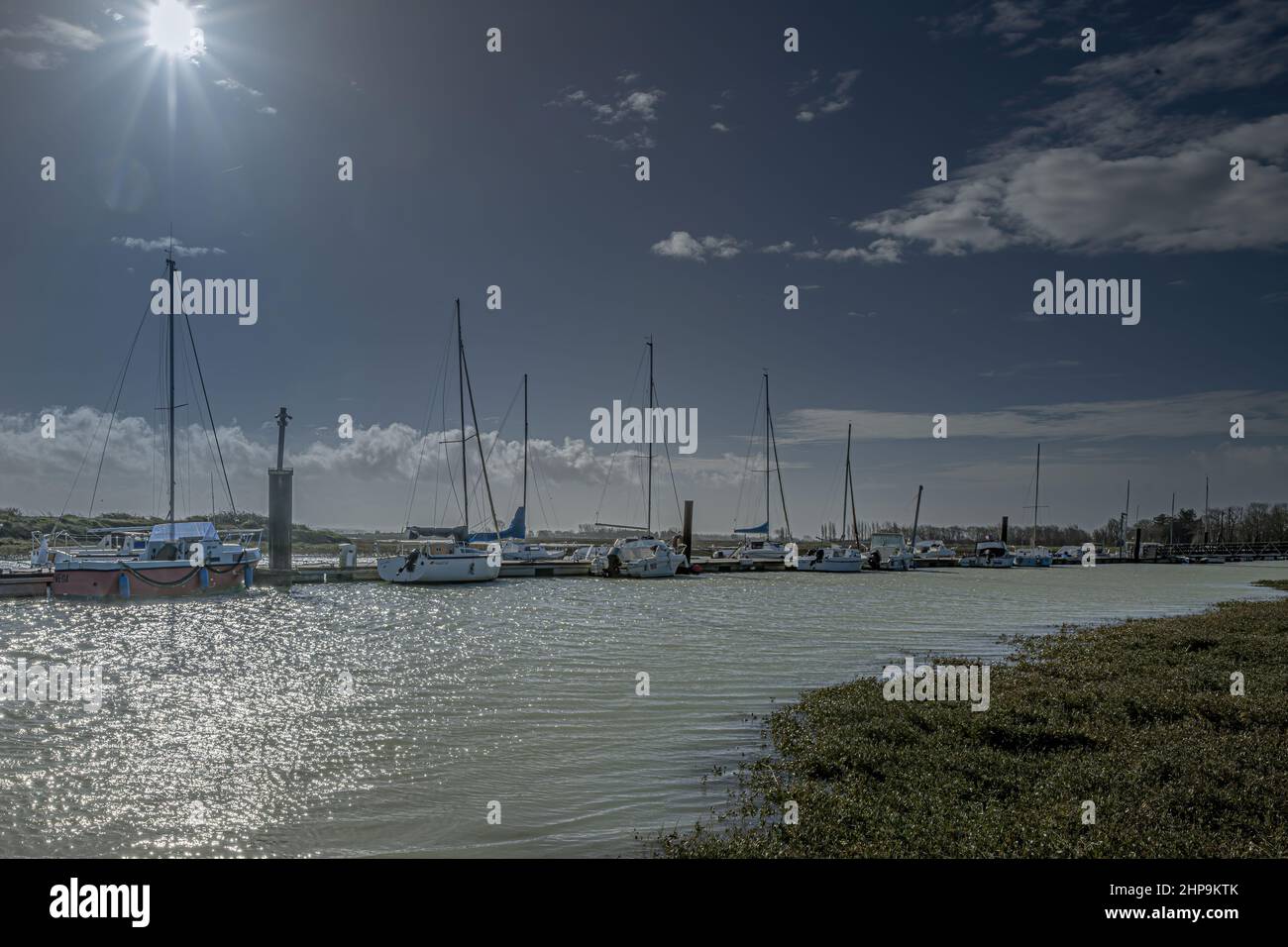 Le Port du Hourdel à marée haute et ses bateaux amarrés. Le phare et la baie de Somme Foto Stock