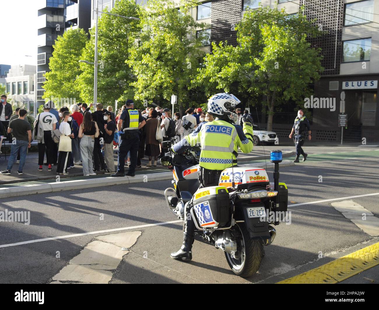 Un ufficiale della polizia Victoria su una motocicletta parla su una radio mentre monitora una folla di manifestanti per i diritti dei rifugiati al Melbourne's Park Hotel. Foto Stock