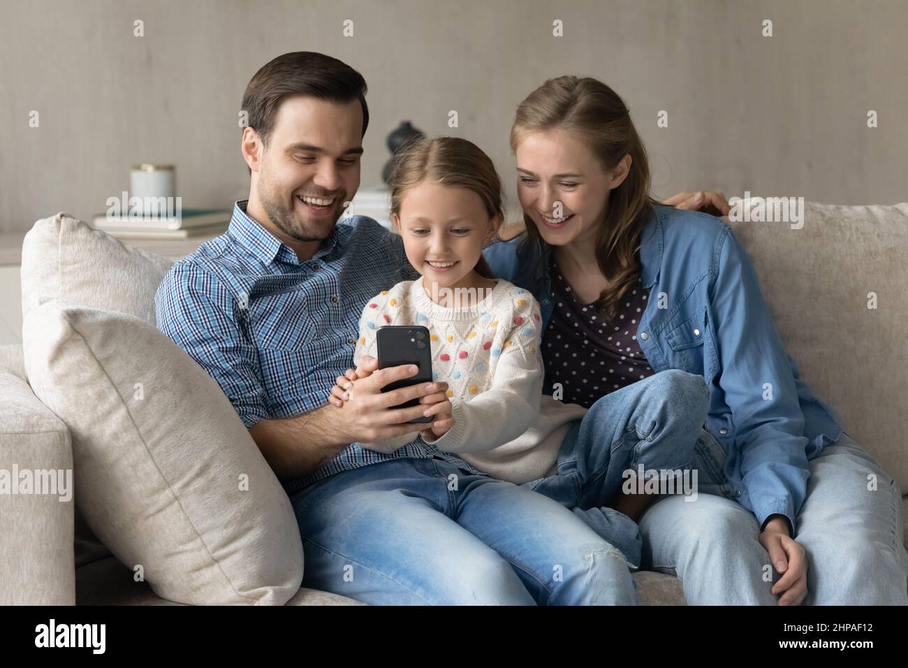 Genitori felici e dolce bambino figlia che riposa sulla tosse confortevole Foto Stock