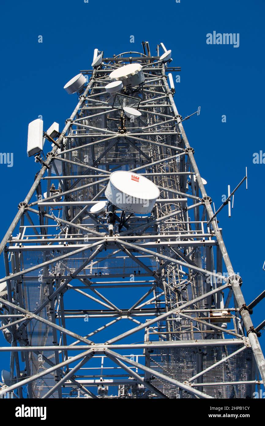 torre per telecomunicazioni con antenne su un cielo blu Foto Stock