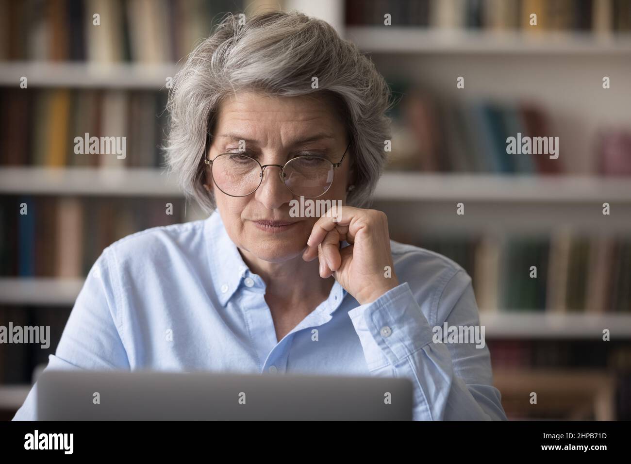 Donna d'affari concentrata di mezza età che lavora su un notebook. Foto Stock