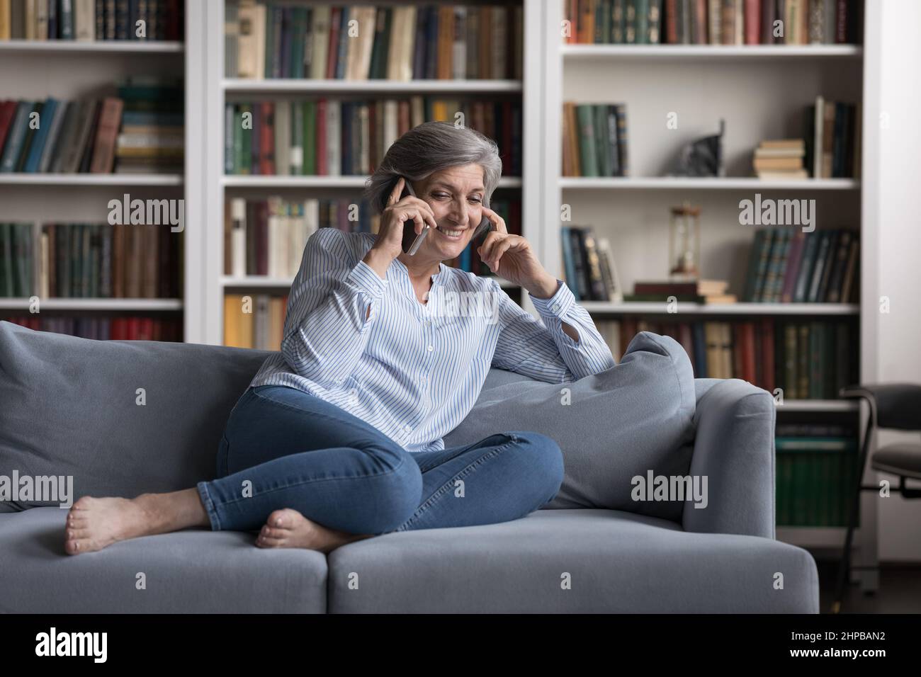 Felice bella donna di mezza età in attesa di conversazione telefonica. Foto Stock