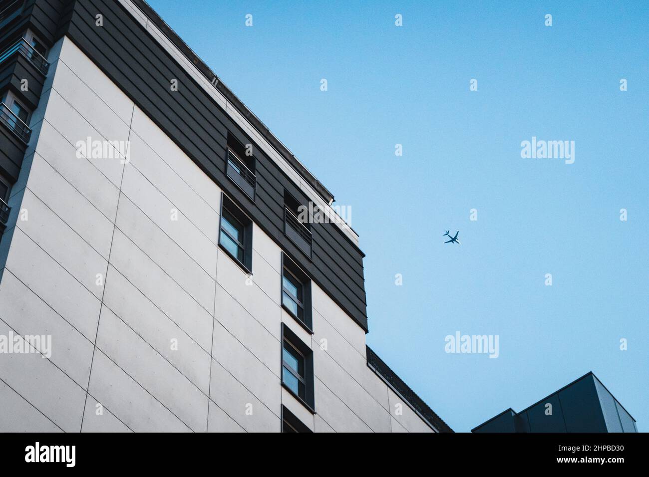 Edificio alto a Bruxelles, Belgio. L'aeroplano vola nel cielo blu senza nuvole sopra Foto Stock