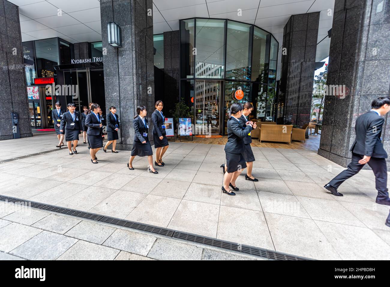 Tokyo, Giappone - 31 marzo 2019: Kyobashi Edogrand moderno centro d'affari entrata della costruzione e molti gruppo giovani donne d'affari donne d'affari lavoratori d'ufficio cand Foto Stock