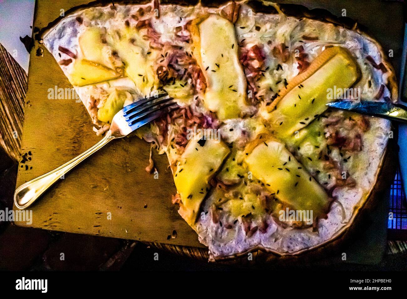 Flammkuchen non dovrebbe mancare in nessun viaggio in Alsazia. È disponibile in molte varianti. Qui la versione con abbondante formaggio Munster Foto Stock