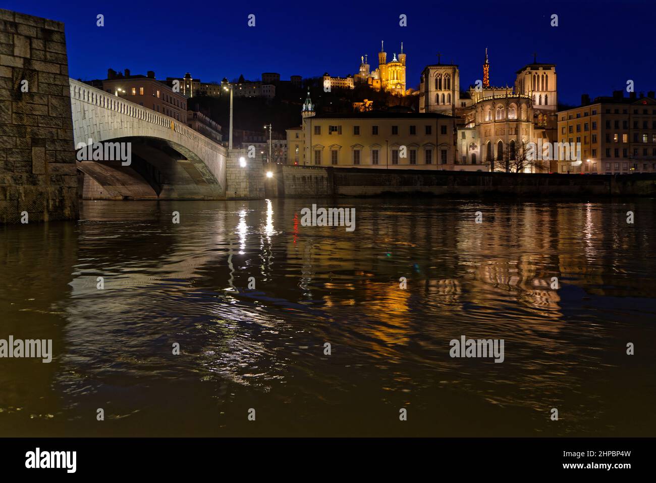 LIONE, FRANCIA, 19 febbraio 2022 : Cattedrale di St-Jean, Basilica di Fourviere e ponte Bonaparte riflettono nelle acque del fiume Saone all'ora blu. Foto Stock