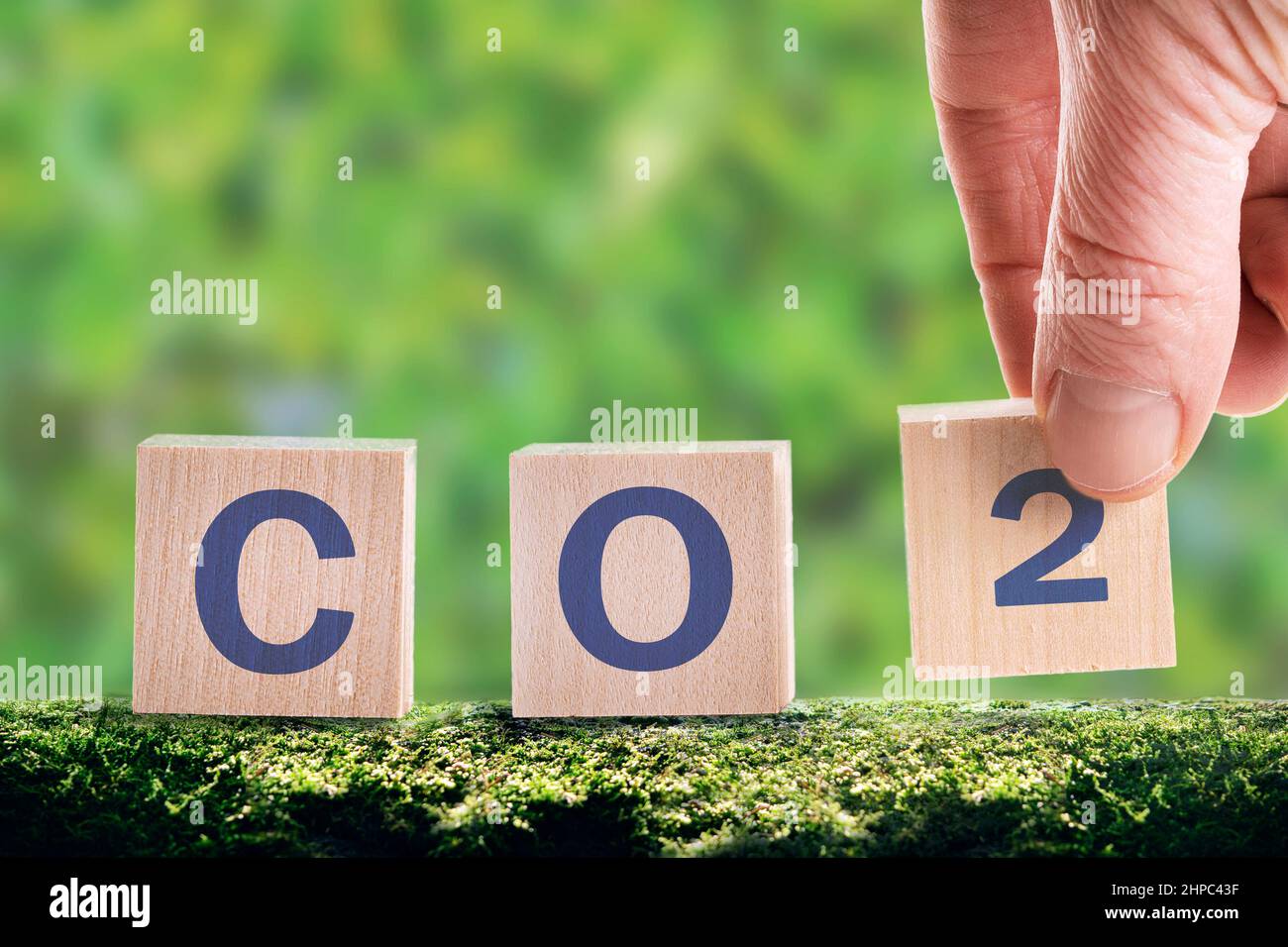 CO2 cubi su sfondo verde, il concetto di risparmio energetico e riduzione delle emissioni. Ridurre le emissioni del CO2 per limitare il riscaldamento globale e il cambiamento climatico. Foto Stock