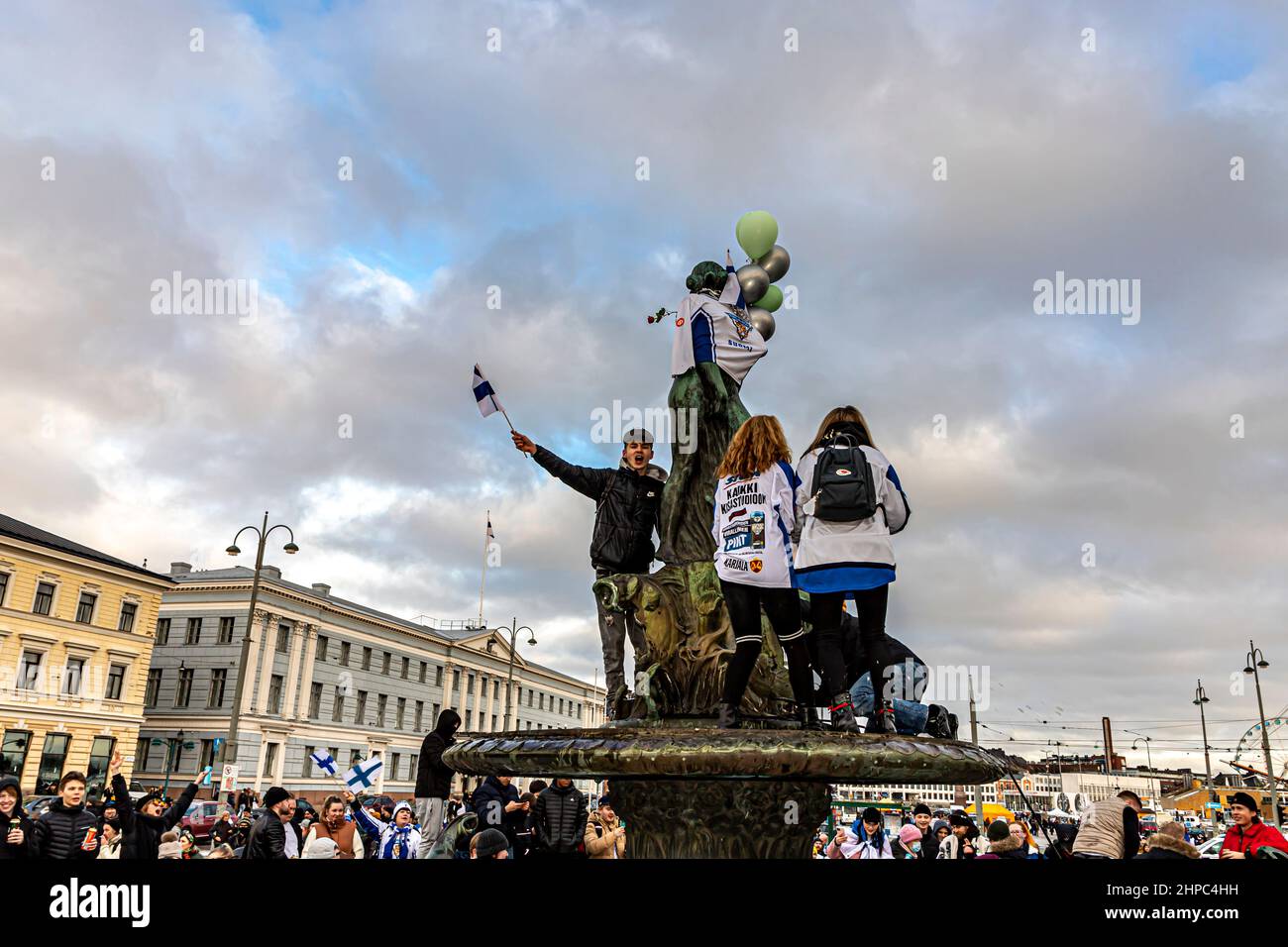 Gli appassionati di hockey sulla statua di Havis Amanda nella piazza del mercato di Helsinki celebrano la vittoria dell'oro della Finlandia nell'hockey su ghiaccio olimpico maschile. Foto Stock