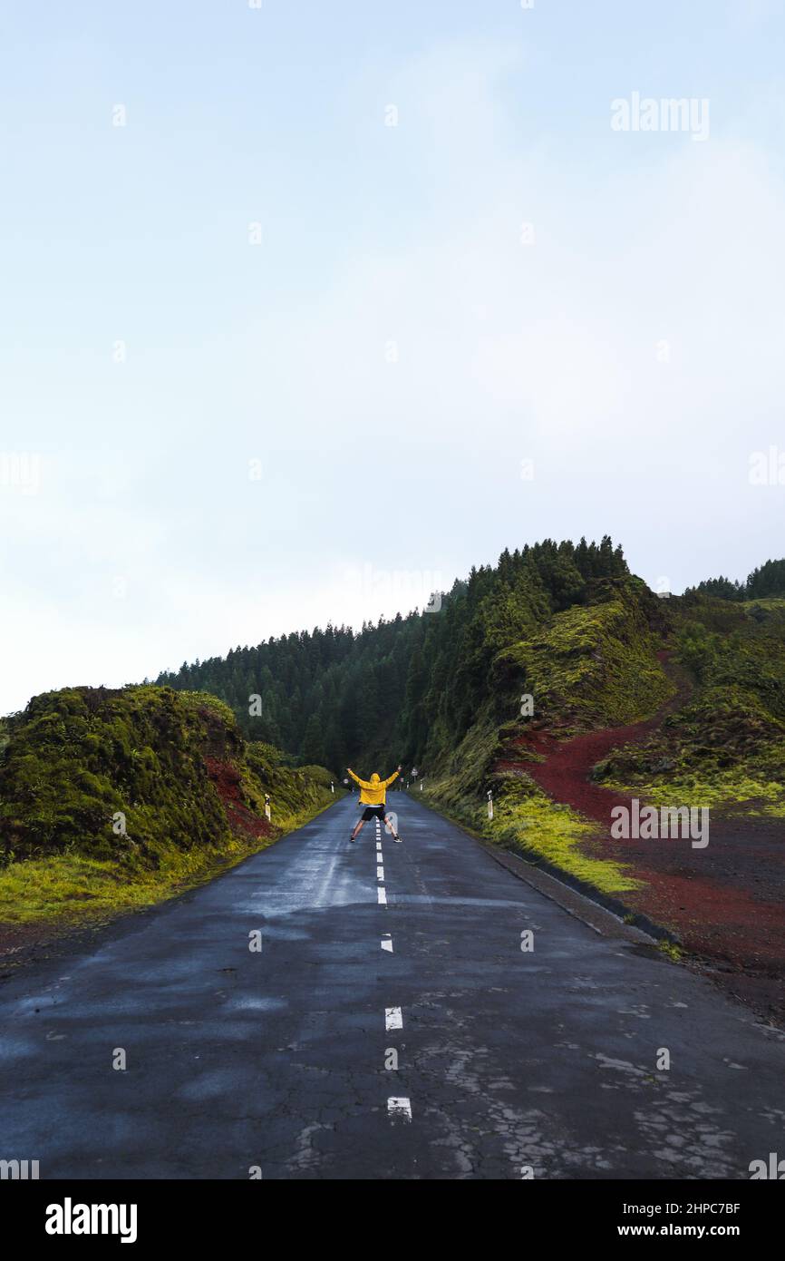 esploratore salta su una strada tra le montagne dell'isola di São Miguel nelle Azzorre, Portogallo. Foto Stock